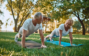 a couple doing yoga at the park