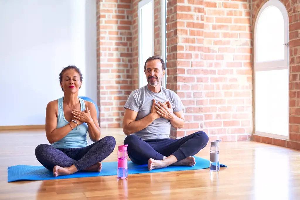 a couple on their mats at a yoga studio